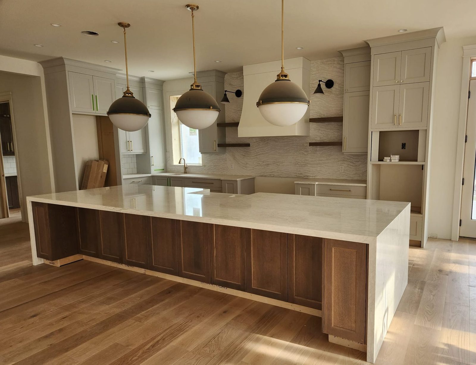 Kitchen island with white quartz waterfall edge and walnut cabinetry